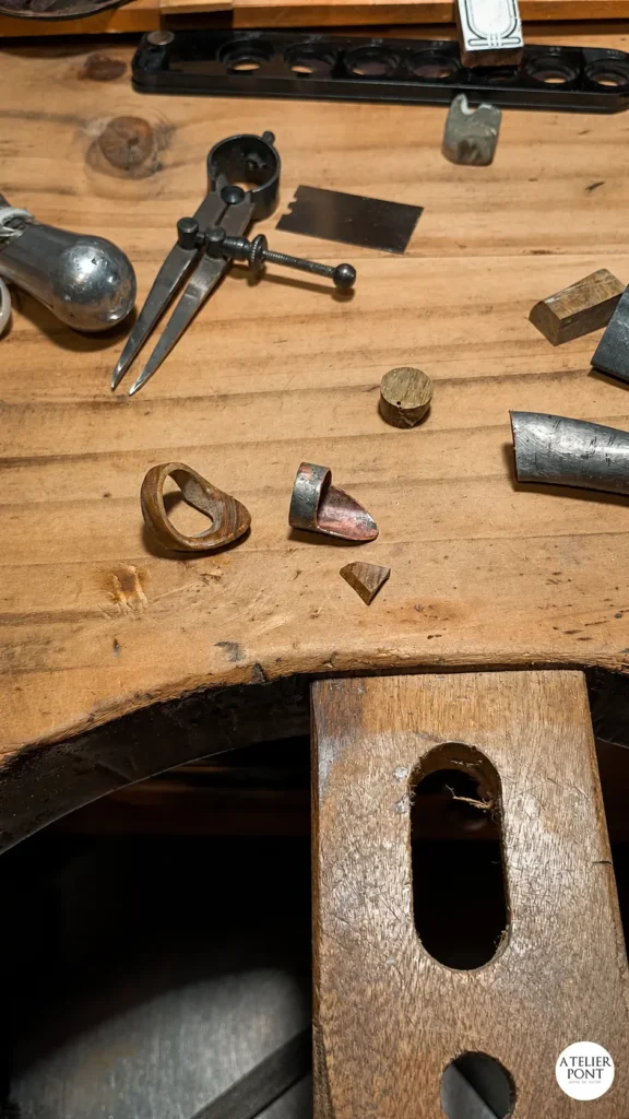 Piezas de madera y cobre preparadas individualmente antes del ensamblado definitivo.