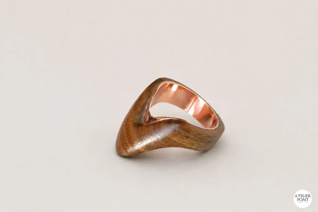 Vista lateral del Anillo Zaha mostrando la transición entre madera de palo santo y cobre reciclado.